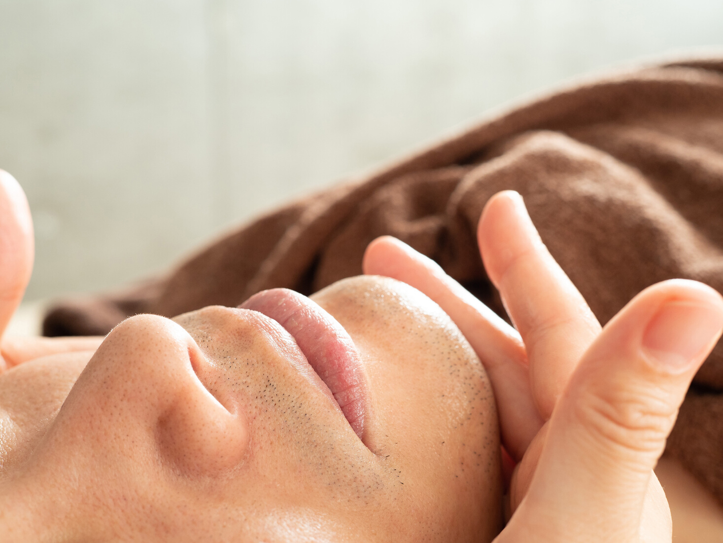 Men applying moisturizing cream after mustache hair removal